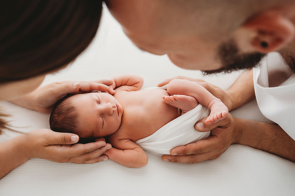close up of new parents holding their newborn baby 