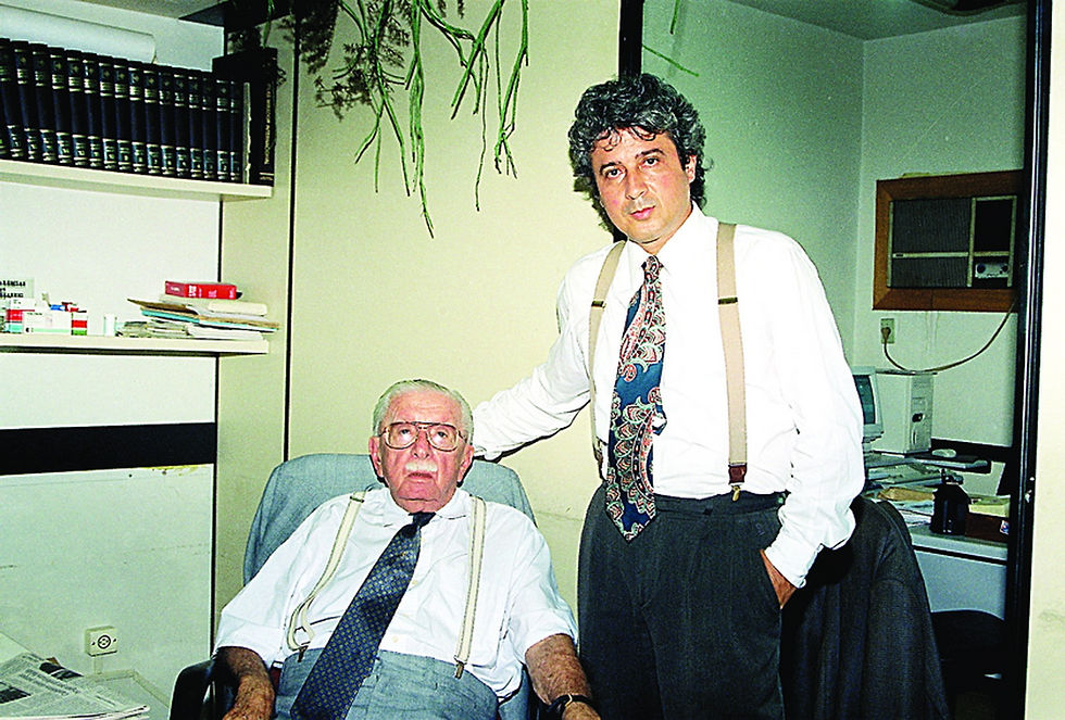 Dois homens, um sentado outro de pé