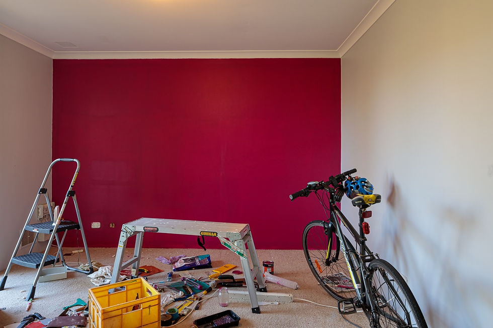 Red feature wall recently painted with uneven coverage
