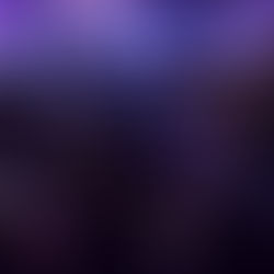 Audience seated in a theater with purple chairs, watching a brightly lit stage. The scene evokes focus and engagement.