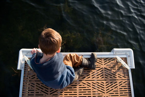 boy on the dock at arbutus lake in traverse city