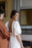 Future mariée qui fini de se préparer avant de partir à l'église. Chignon bas souple et makeup frais et lumineux réalisé par Cécile Teyssier. Chateau de Chavagneux.