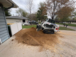 Bobcat loader moving a pile of dirt