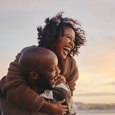 a smiling couple watching a sunset