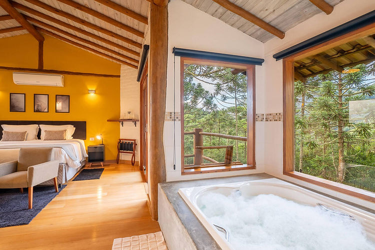 Interior do chalé com cama super king e hidromassagem dupla, na Pousada Casa Campestre