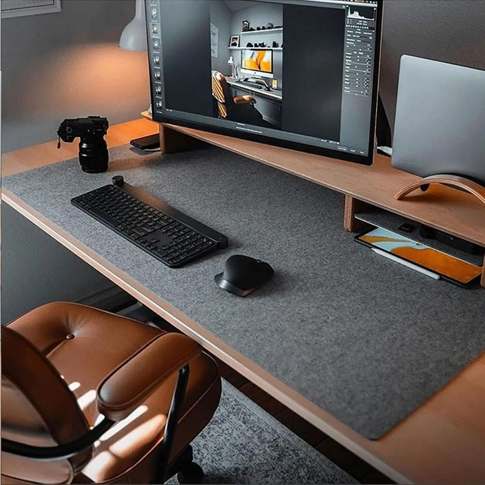Minimalist dark grey felt desk pad styled in a high end dual monitor workspace setup