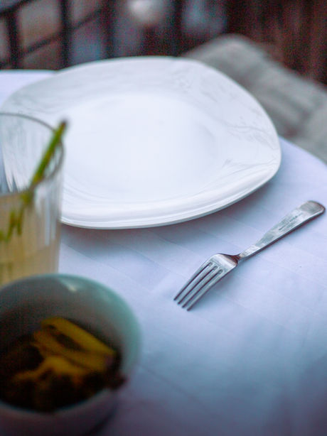 Une assiette et une fourchette sur une table, sur un balcon