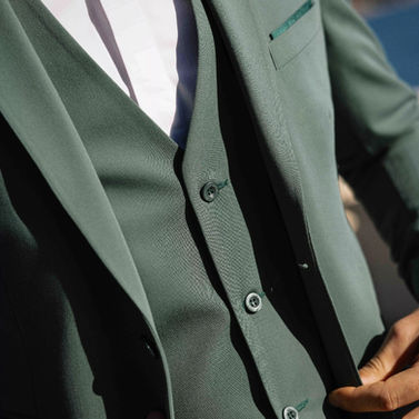 Homme ajustant son costume vert et gilet