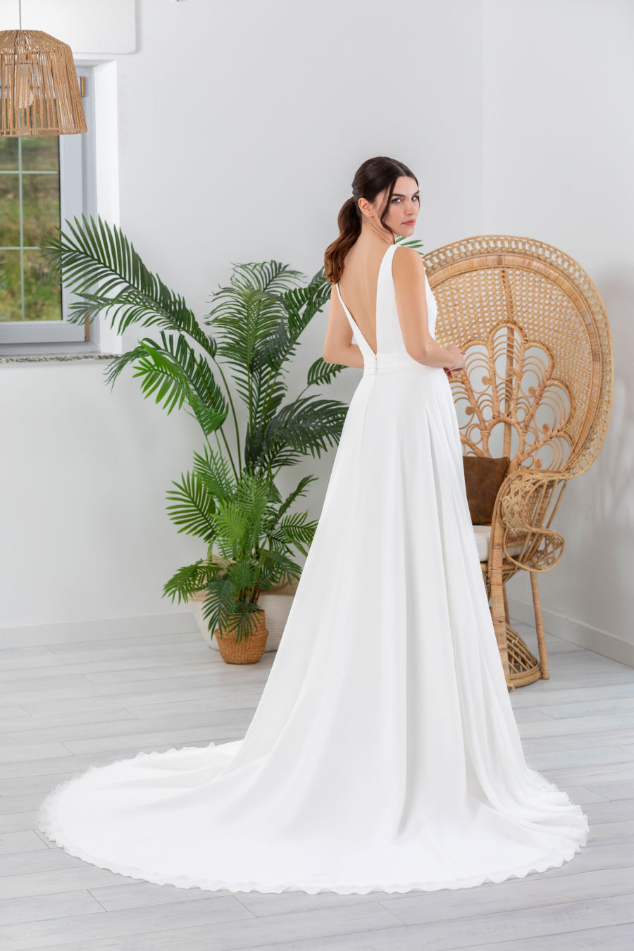 Femme en robe de mariée blanche, dos nu, longue traîne.