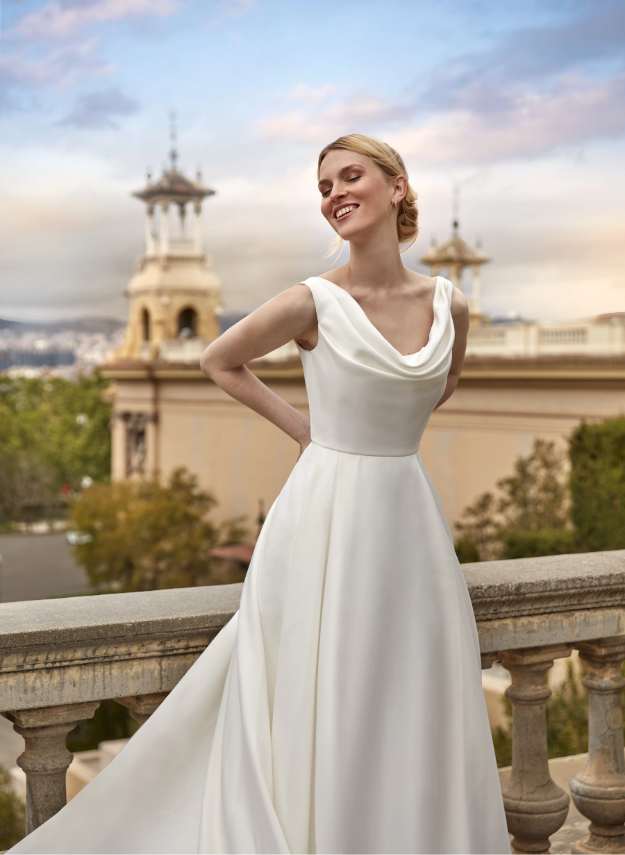 Mariée en robe blanche, décolleté drapé, sur balcon