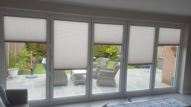 White 5 panel bifold fitted with white honeycomb Bloom Blinds.jpg