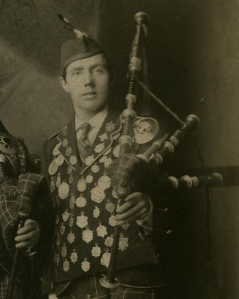 Photo of Angus Craig (cofounder of the Utah Pipe Band) wearing Scottish Highland attire and holding bagpipes.