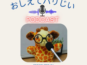 Podcast収録中のキリンのぬいぐるみ。眼鏡をかけてマイクに向かう姿がユーモラス。