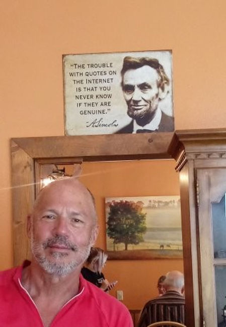 JRW Case posing below a photo of Lincoln