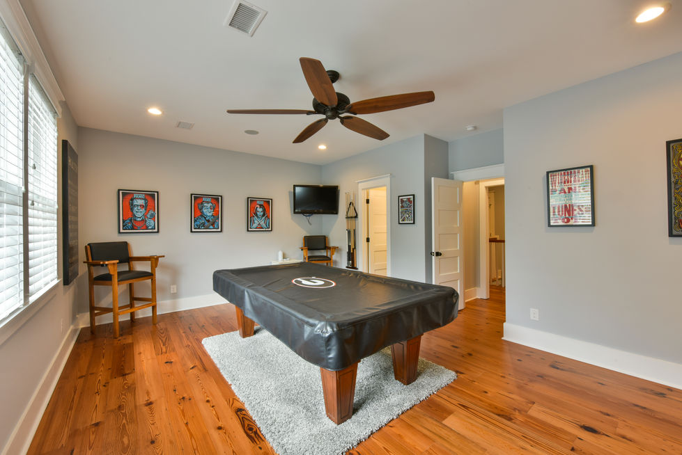 a pool table in a room with a ceiling fan