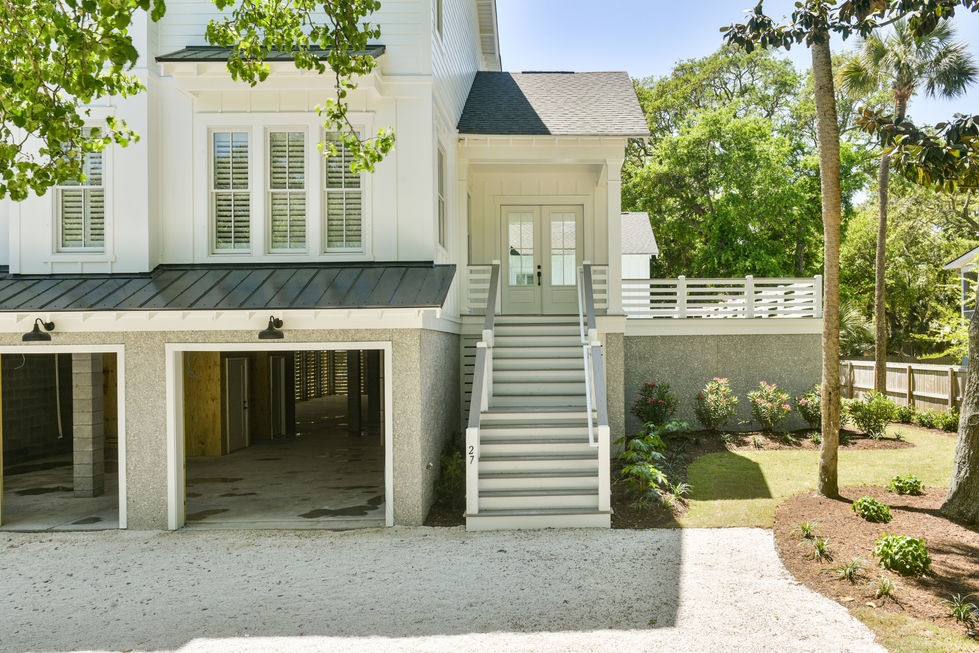 a white house with stairs leading up to the front door