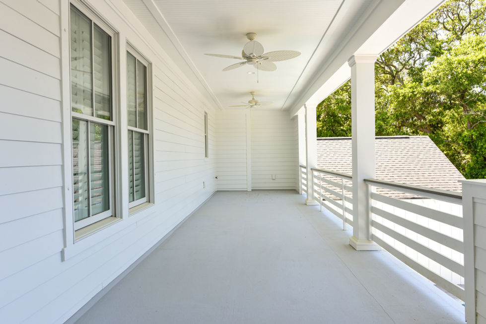 a white porch with two ceiling fans on it
