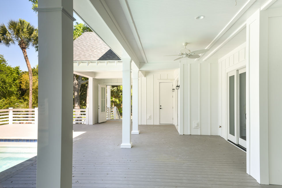 an empty porch with a ceiling fan and a door
