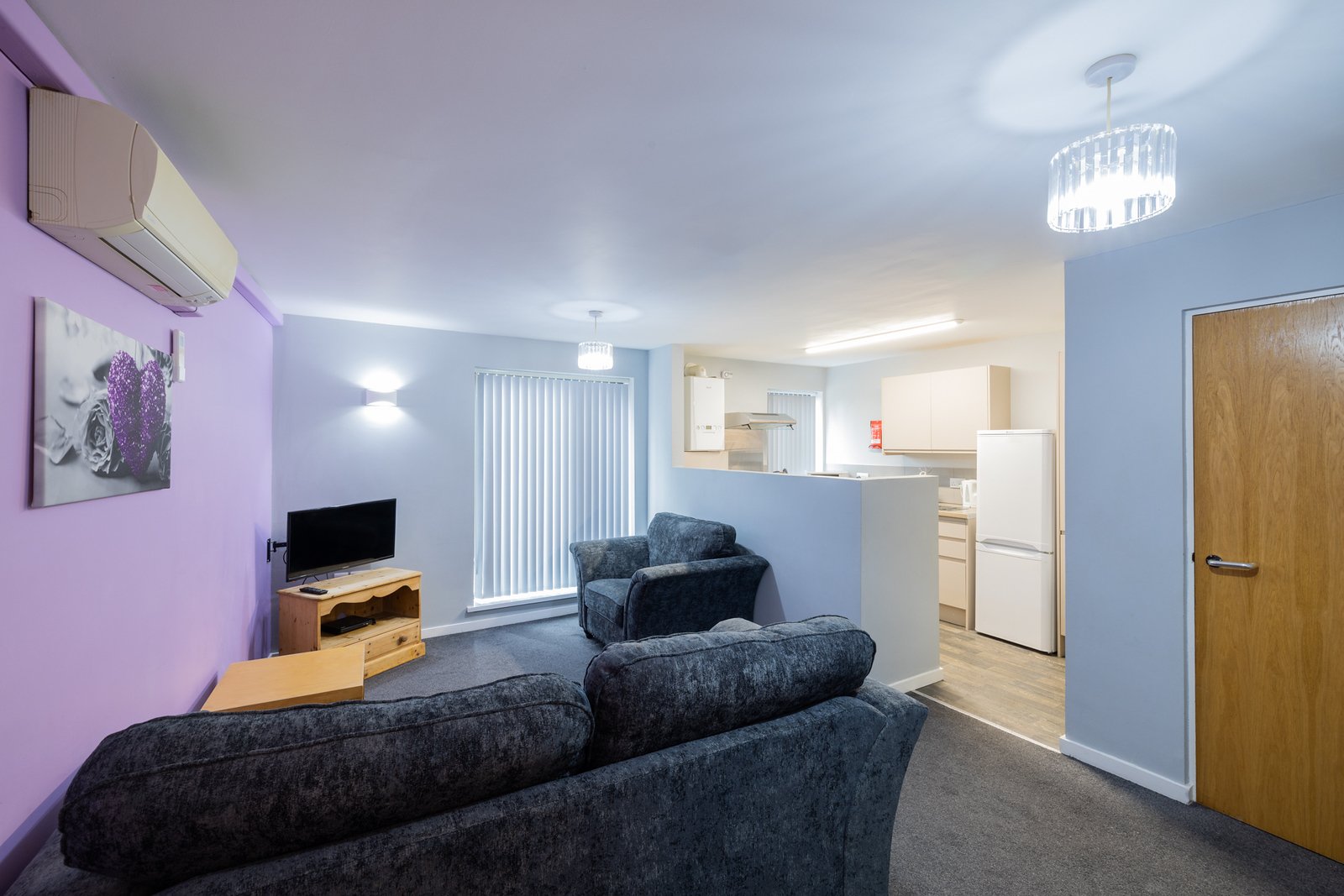 Kitchen and Lounge area with sofa, chair and TV