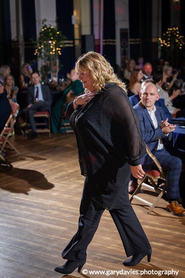 Denise Farman, CEO of Women's Aid NEL, walking to the stage to receive her award