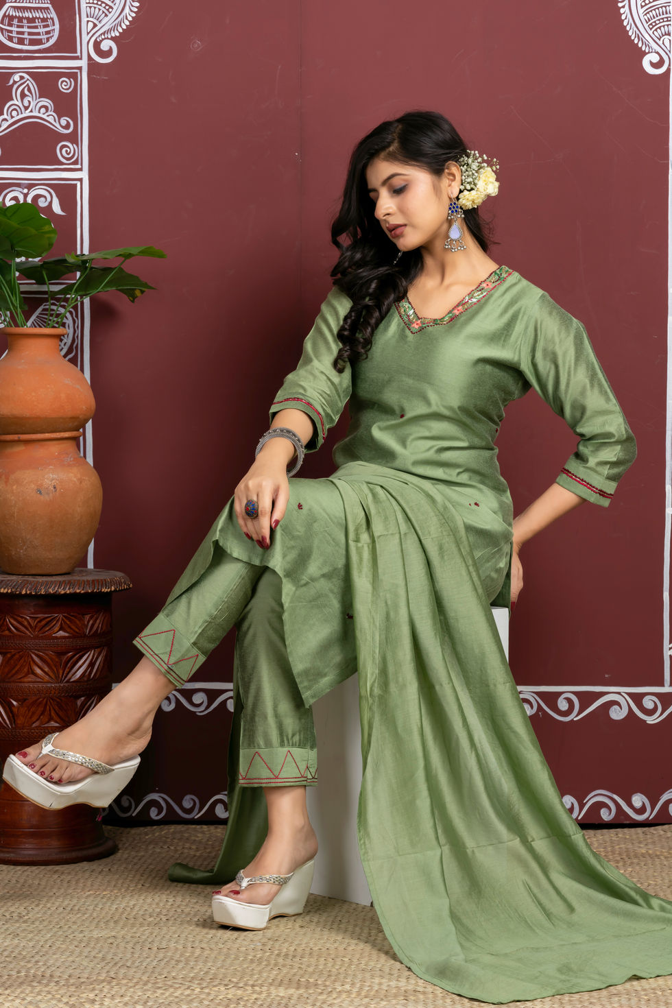 Woman in green Indian suit with earrings
