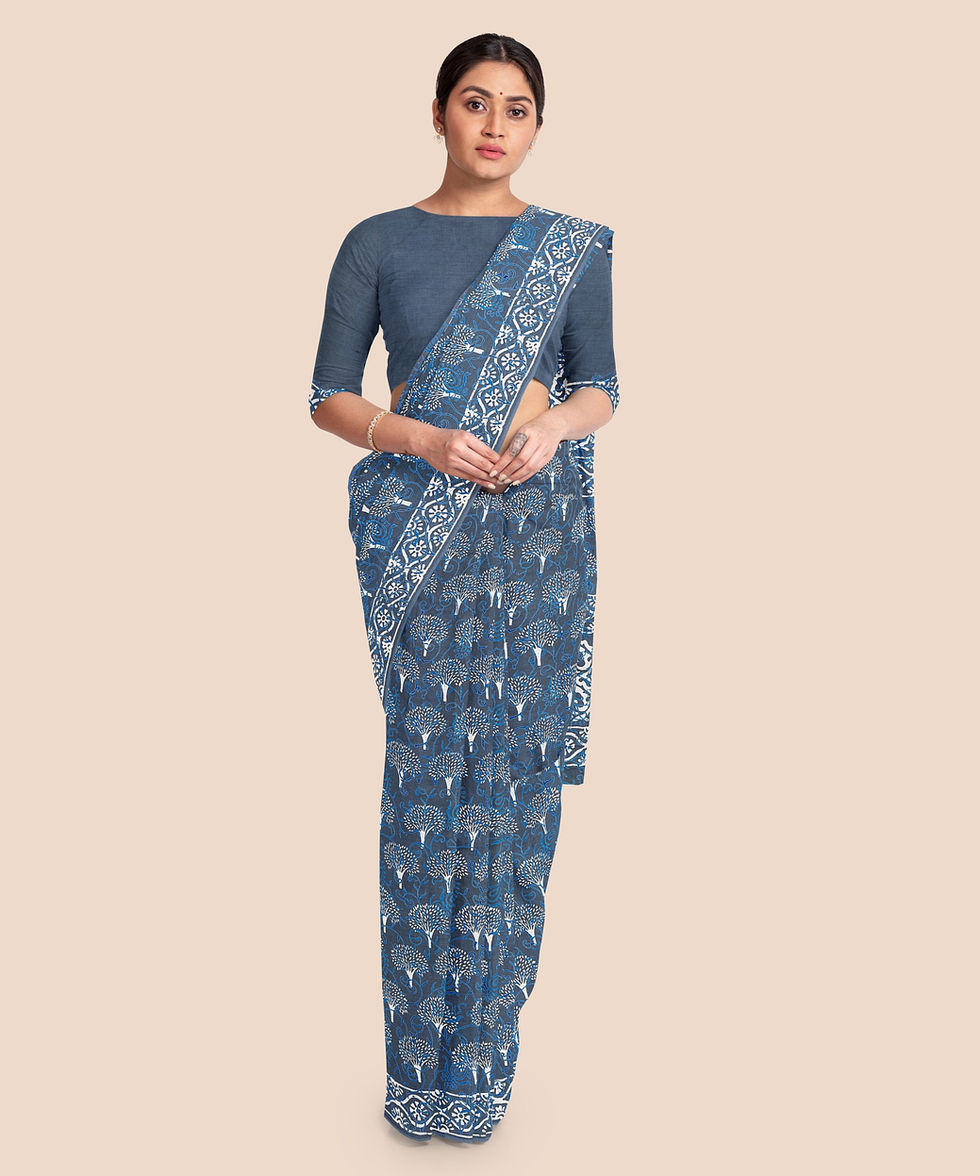 a woman wearing a blue saree with trees on it