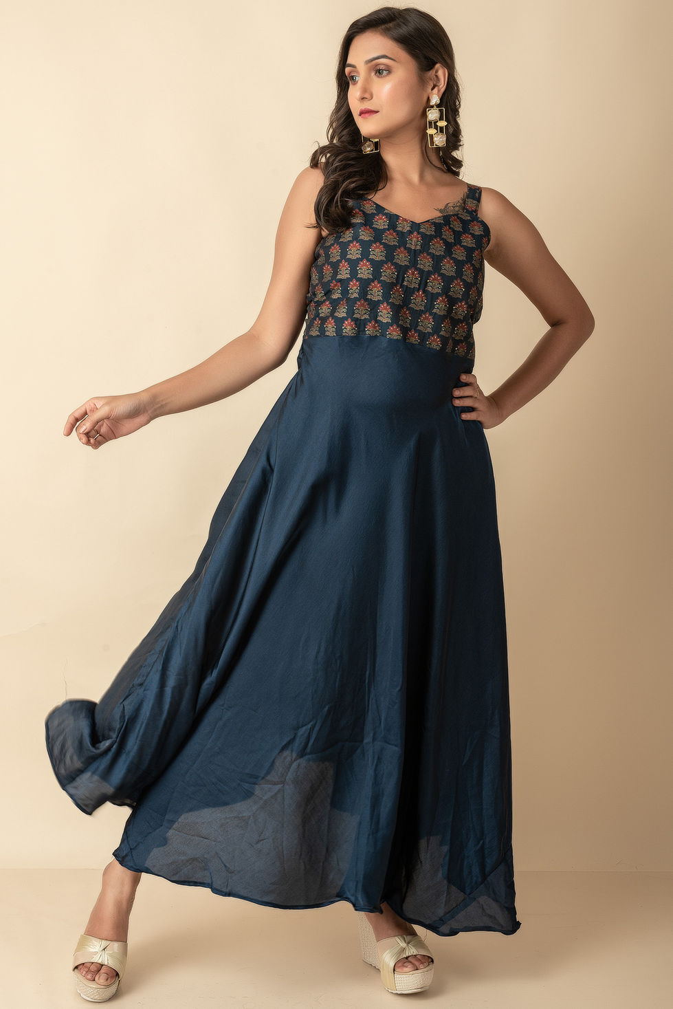 a woman is wearing a blue dress with a floral pattern on the top