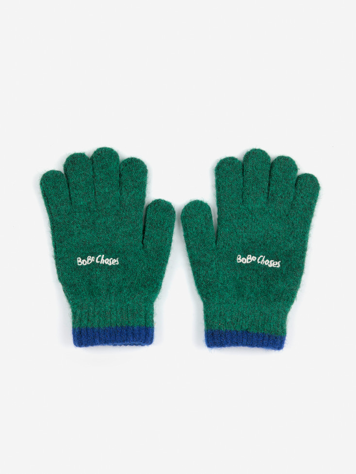 Green knit gloves flat lay with blue trim and Bobo Choses logo