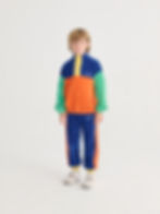 Child wearing blue and orange sweatpants with a matching color-block jacket.