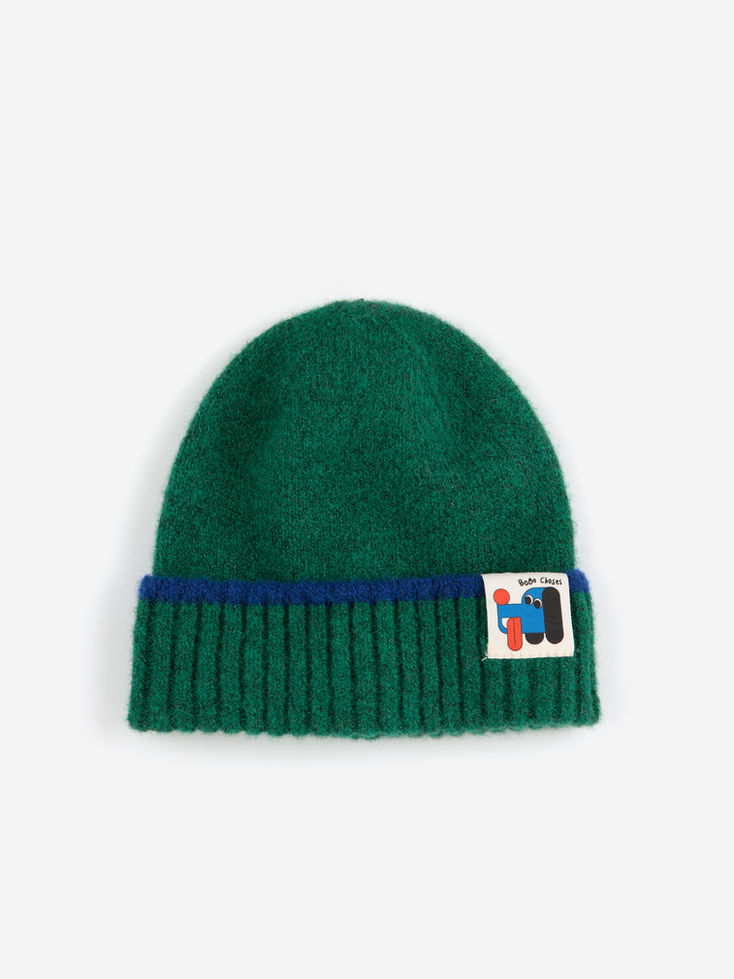 Flat lay of Bobo Choses green beanie with blue trim and dog patch logo