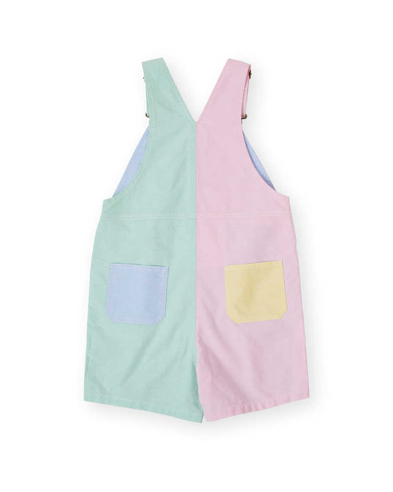 Back view of pastel color-block overalls with contrasting panels and back pockets.
