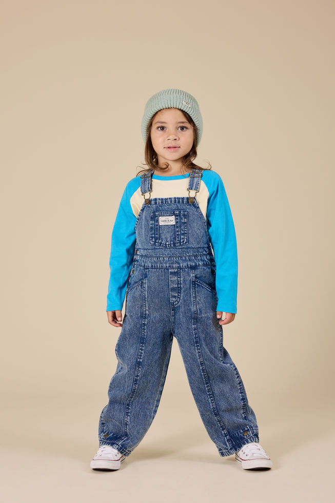 Child wearing the Blake Dark Denim overalls with a blue sweater