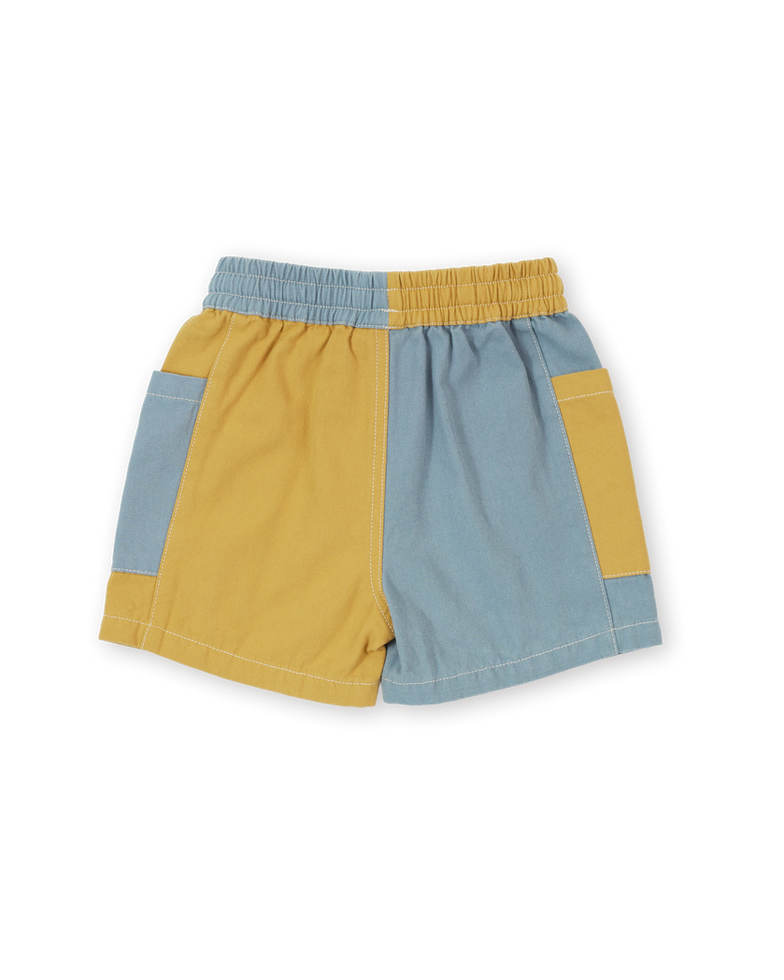 Back view of the color-block shorts with yellow and light blue panels and elastic waistband.