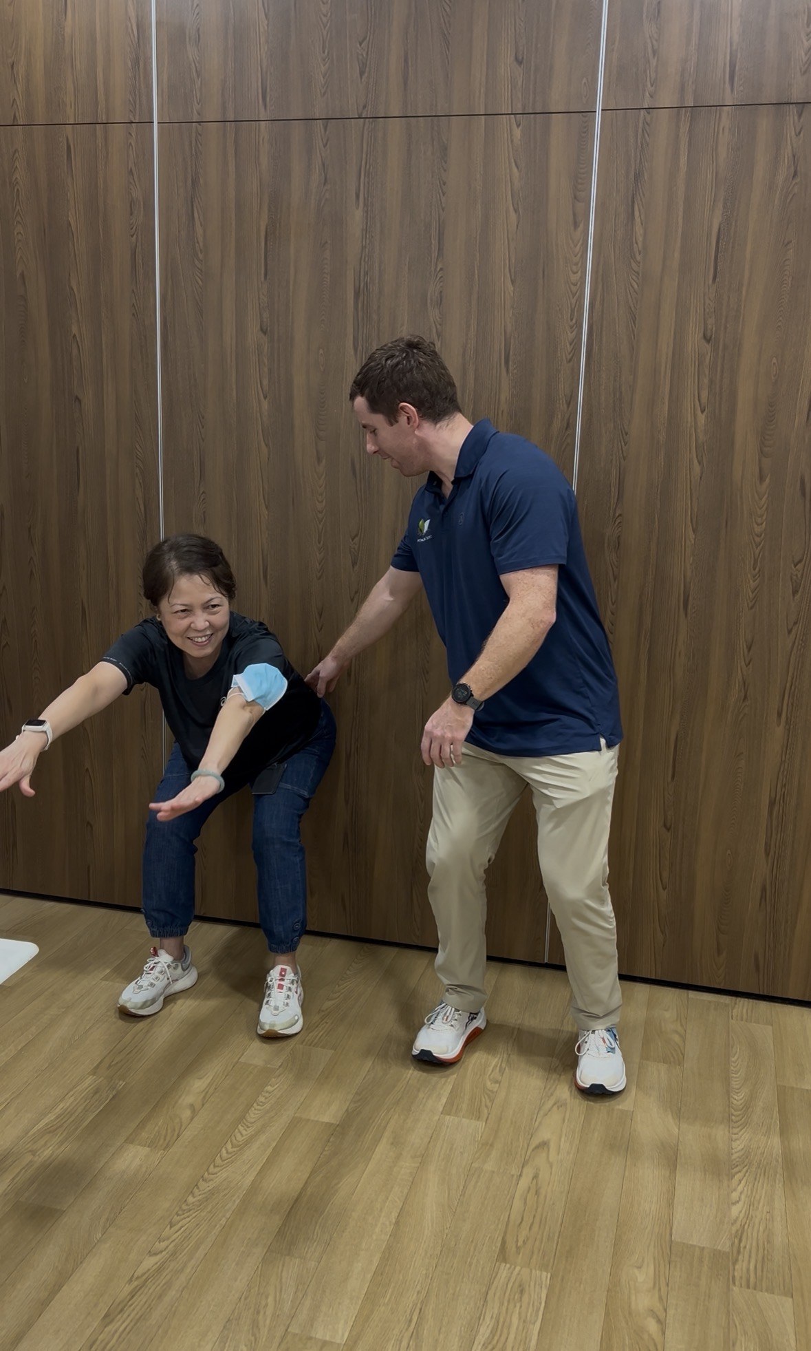 Chiropractor coaching an attendee through a squat