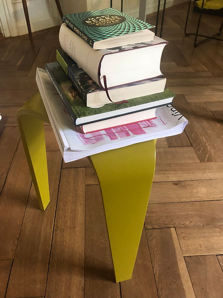Bücherstapel auf einem gelbem Hocker