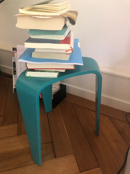 Bücherstapel auf blauem Hocker