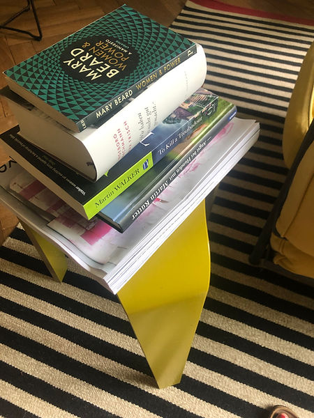 Bücherstapel auf gelbem Hocker