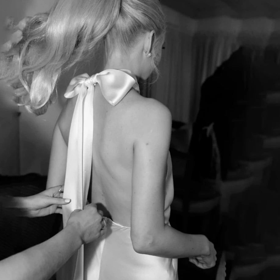 Thumbnail: Minimalist Halter Sheath Wedding Dress – Backless Satin Gown, Bow Tie Detail, 
