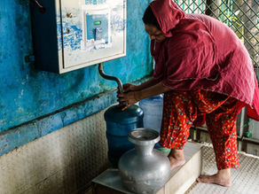 women collecting water from Drinkwell tap