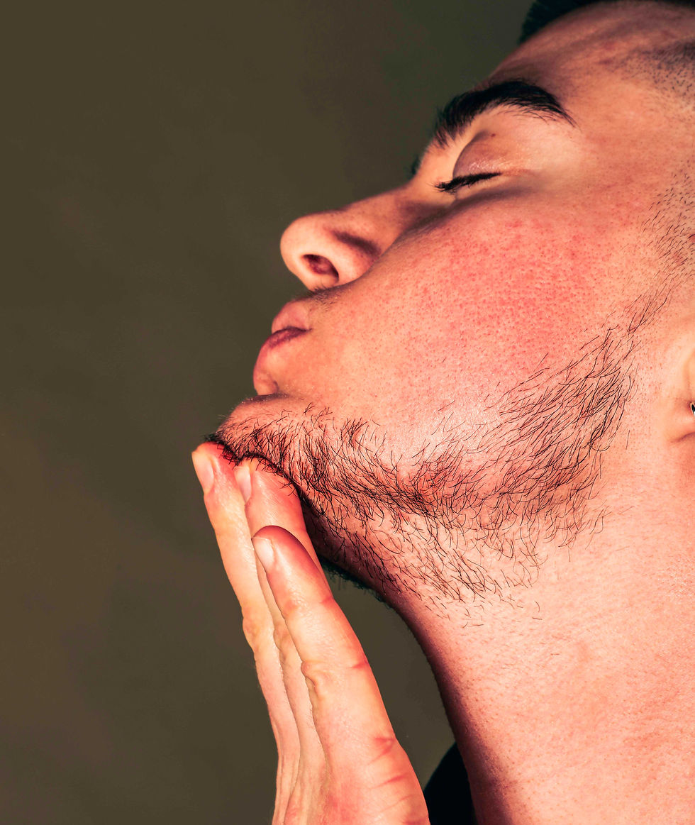 a trans man stroking his beard