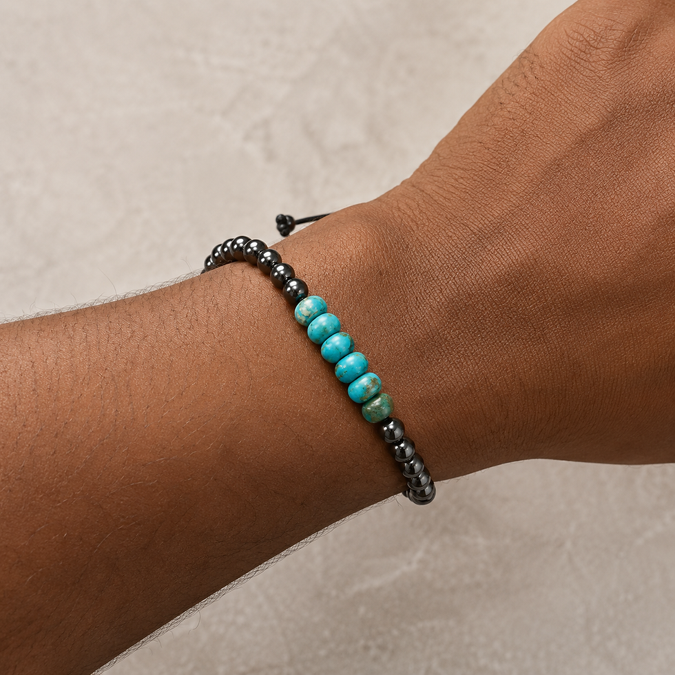 Jasper and hematite adjustable bracelet with black beads, blue-green jasper stones, and braided cord closure on a wrist.
