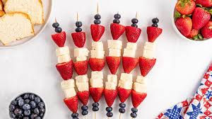 Close-up view of colorful berry shortcake skewers arranged on a plate
