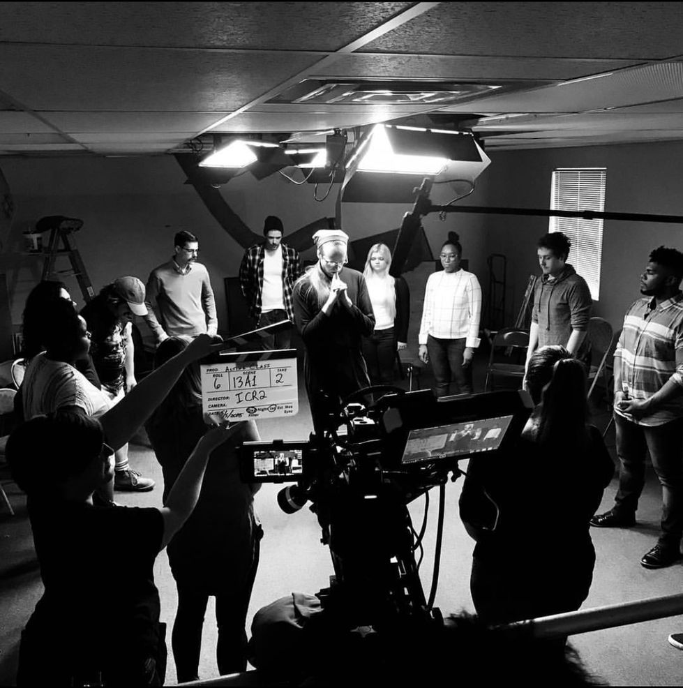 a black and white photo of a group of people in front of a camera with a slate that says " i can " on it