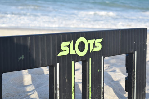 Outdoor game beach SLOTS rolling wheel game best yard fun thing to do black and green tire through slot opening at the beach outside games family friendly easy fun most addicting all ages adult games grass yard outdoors sport sand