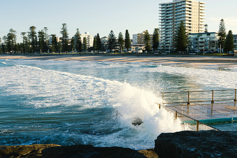 Wave splashing against an ocean pool beside the beach