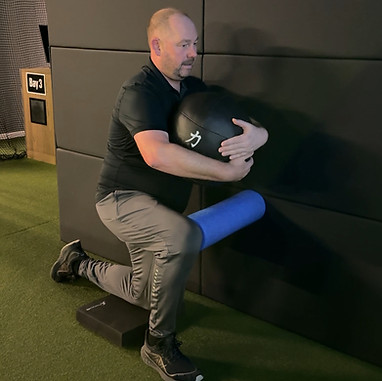 golf fitness client performing a mobility exercise in a golf bay
