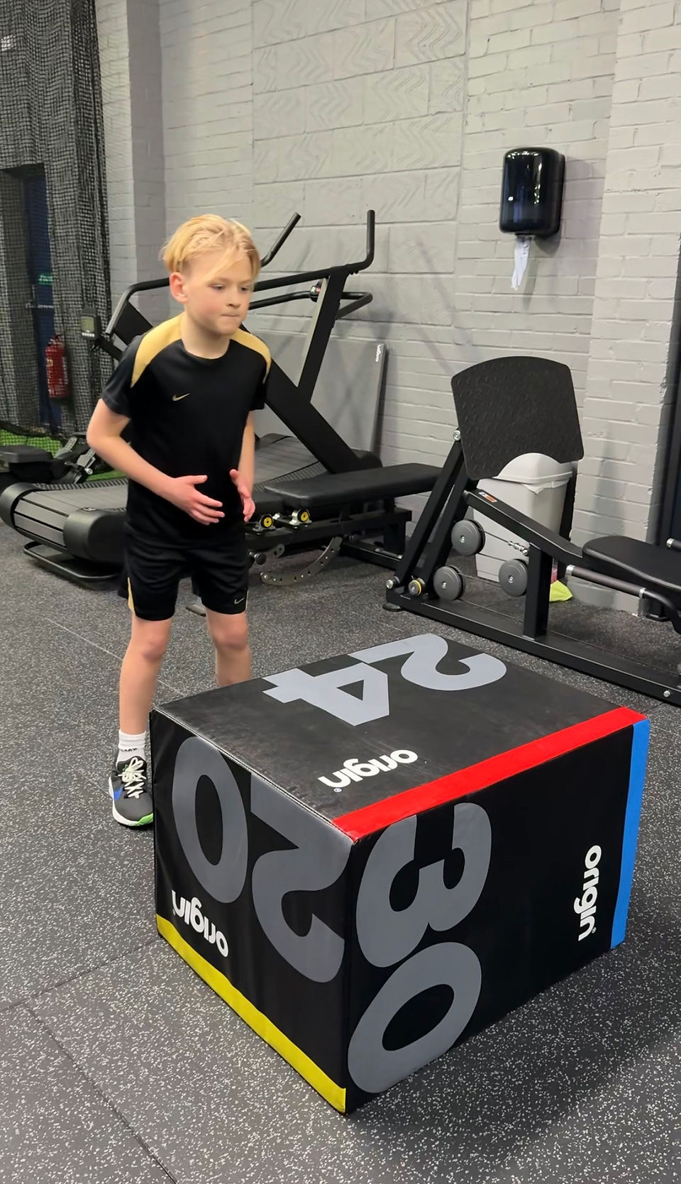 Junior athlete standing in front of a plyometric box ready to perform a box jump