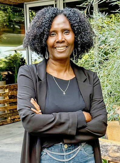 Picture of coach Dominique standing smiling with arms crossed 