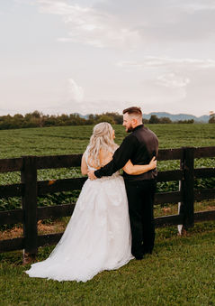 a bride and groom standing next to a black fence