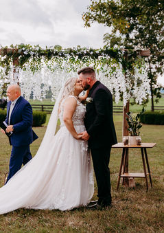 a bride and groom kiss during their wedding ceremony